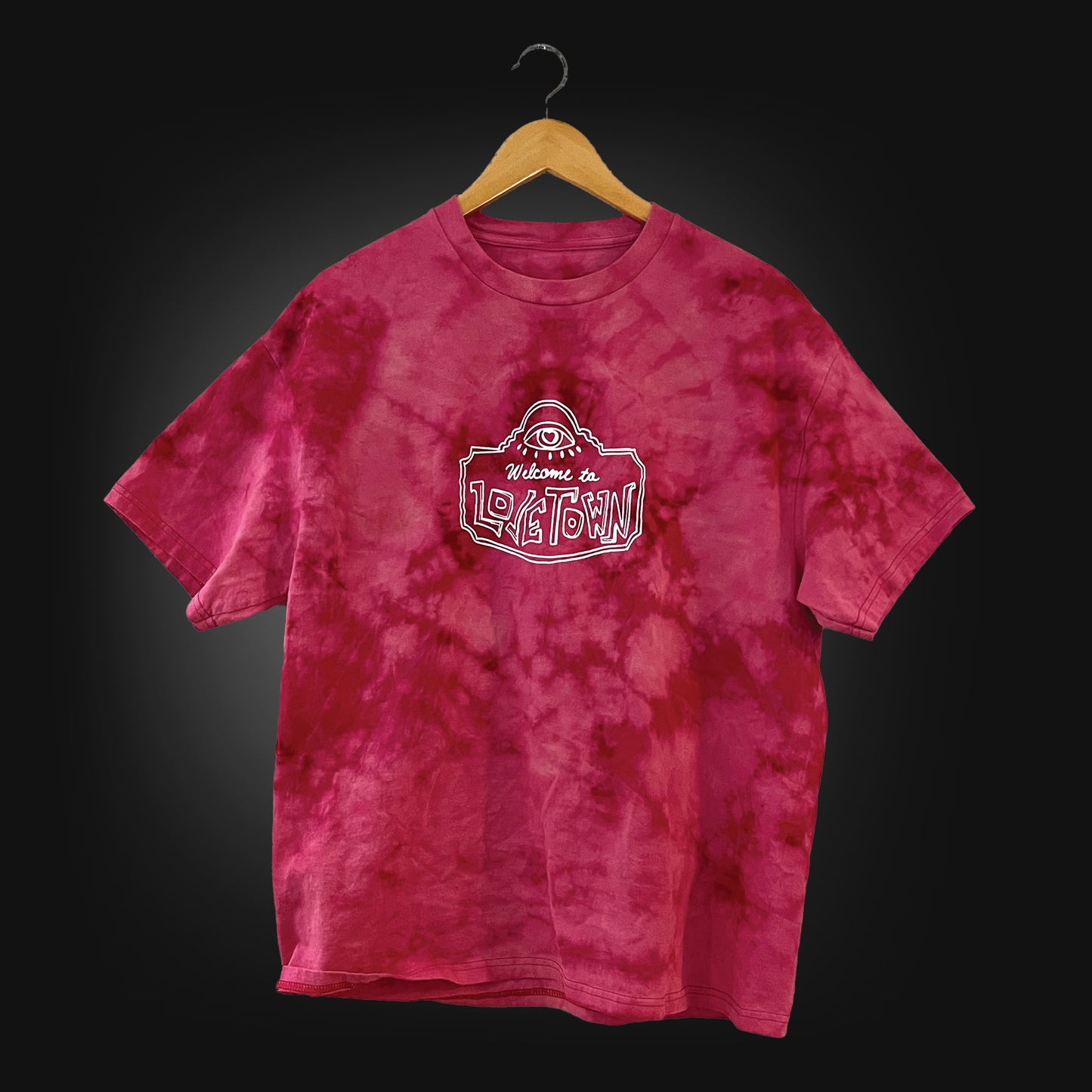 red t-shirt with a white logo that says "welcome to lovetown", tie dyed with bleach.